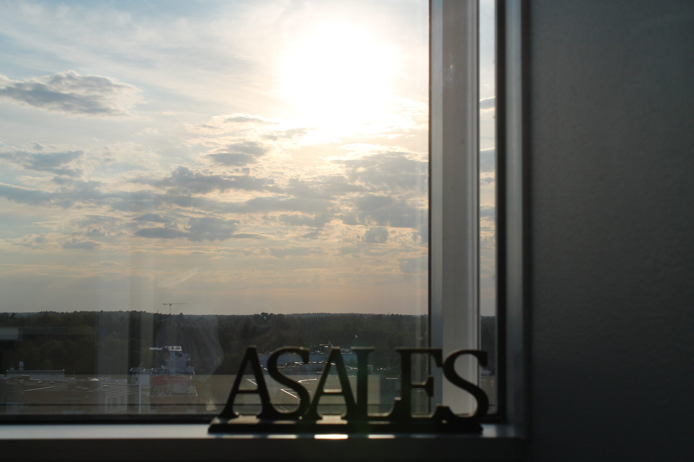 ASales-logo toimiston ikkunalla, näkymä Helsingin ylle